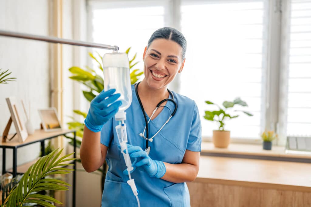 Portrait of a home care nurse adjusting and preparing an IV drip for medical detox