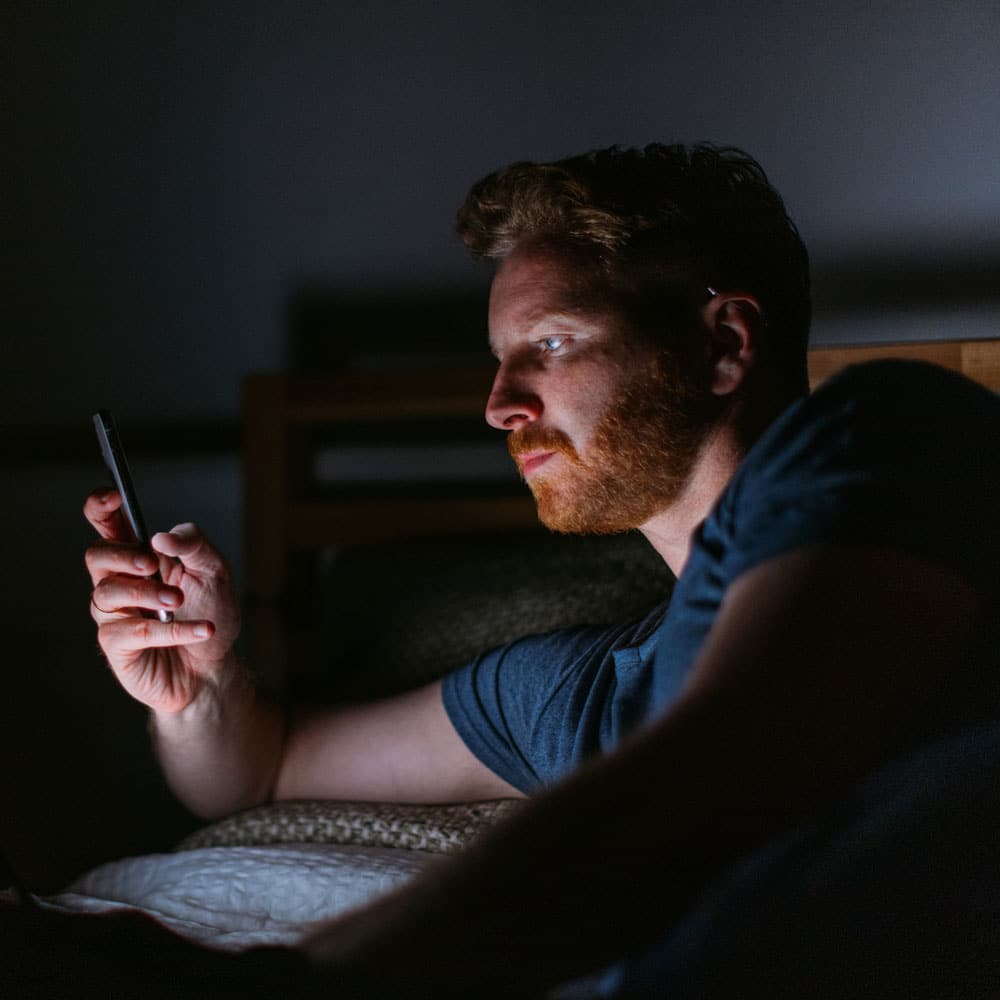 man on phone in bed