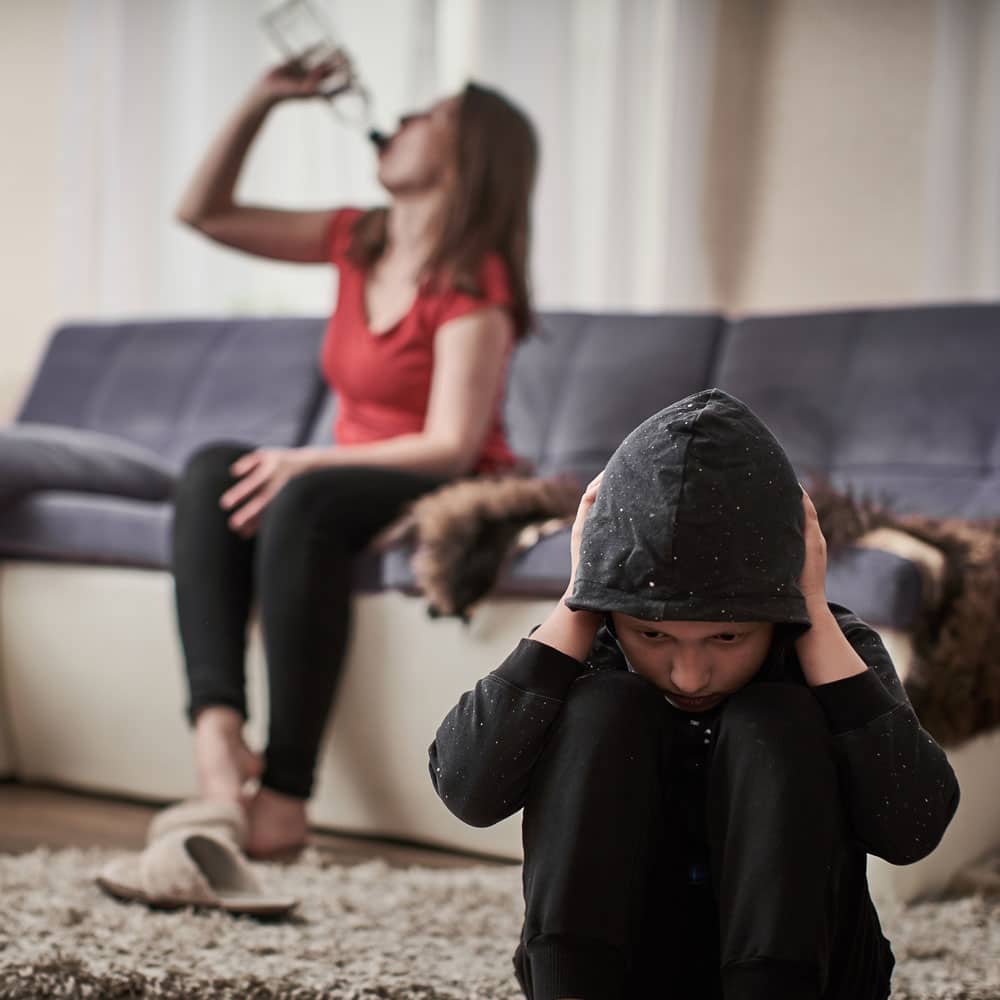 child covering ears around alcoholic parent