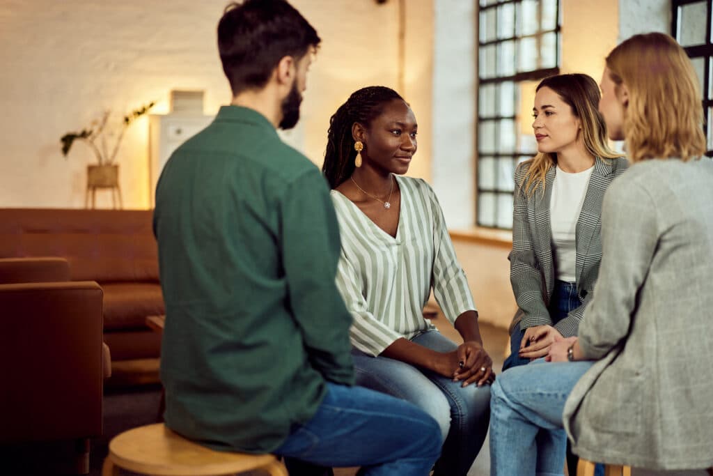 Four people sharing ideas in a comfortable and welcoming conversational environment indoors.